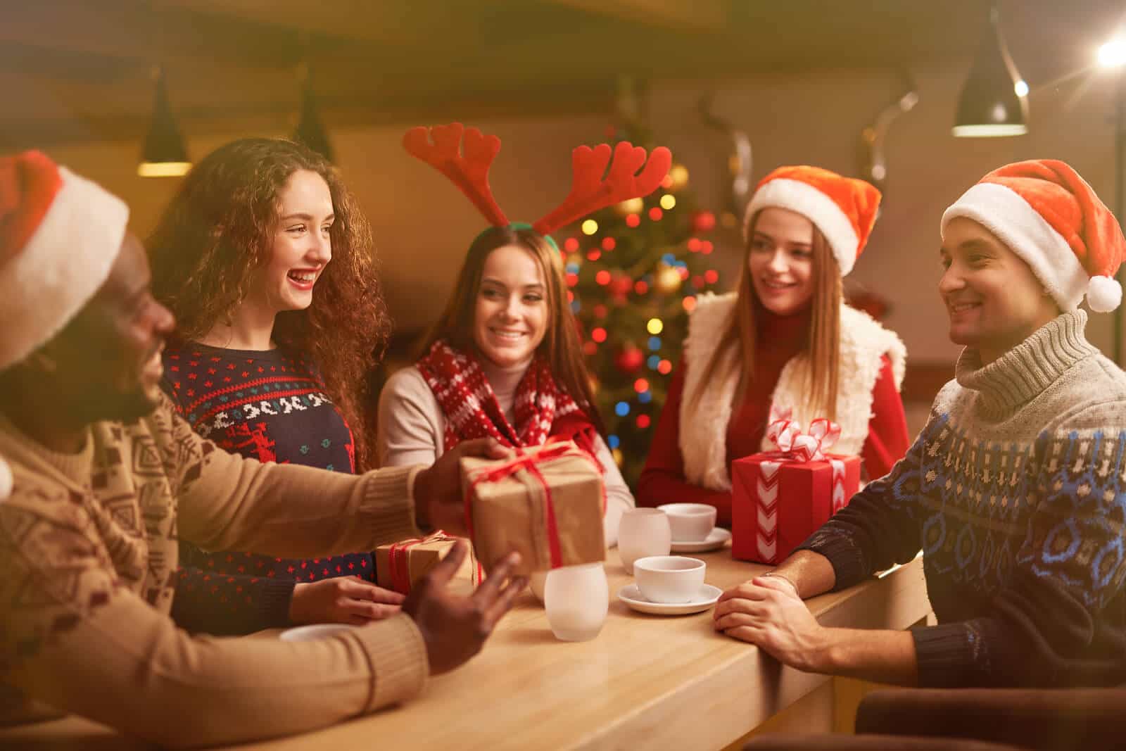 Happy young friends congratulating each other on Christmas eveni