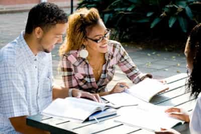 group of college students studying on a bench